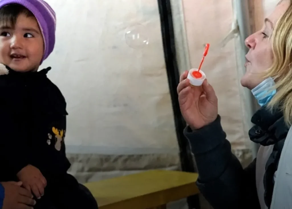 Ärzte ohne Grenzen, Ärztin spielt mit Kind und Seifenblasen